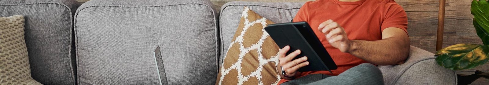 a person sitting on their couch viewing their tablet